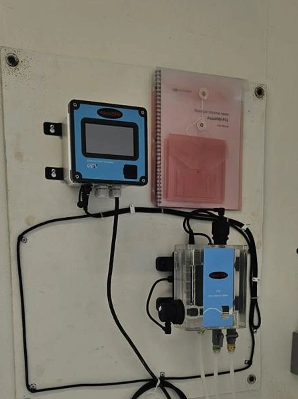 Industrial control panel and instruments mounted on a white wall.