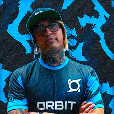 Man with tattoos and glasses wearing an Orbit esports jersey against a blue graphic background.