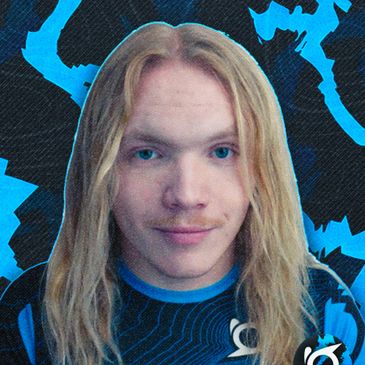 Young man with long blonde hair against a blue patterned background.
