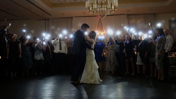 Bride and groom share a dance surrounded by guests holding up lights.
