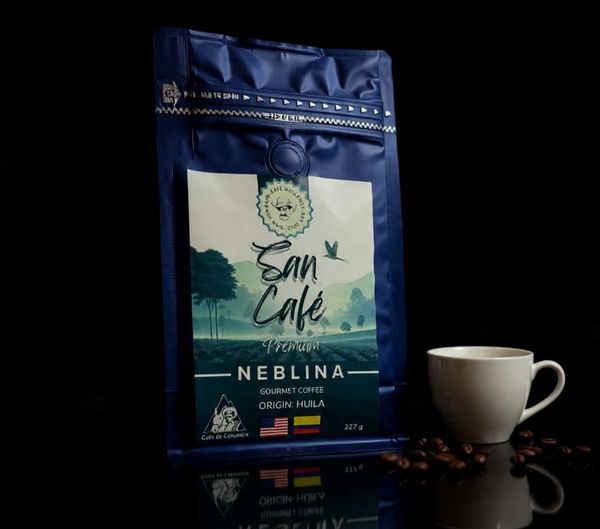 A bag of San Café Neblina gourmet coffee with a white cup and coffee beans.