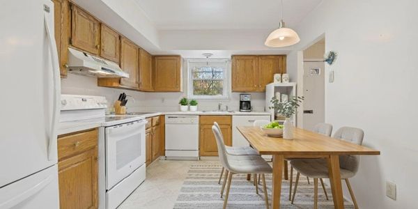 Bright kitchen with wooden cabinets and dining table.
