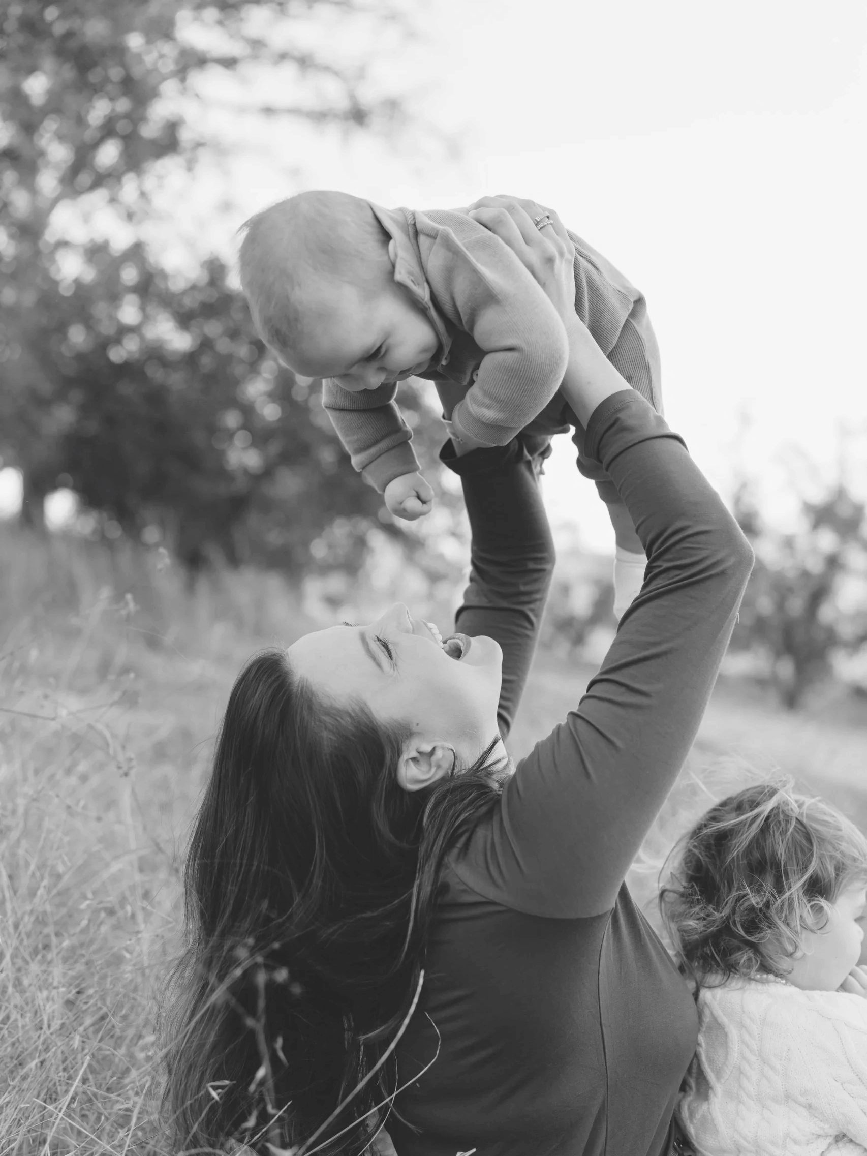 Mom holding baby up in the air with big smiles