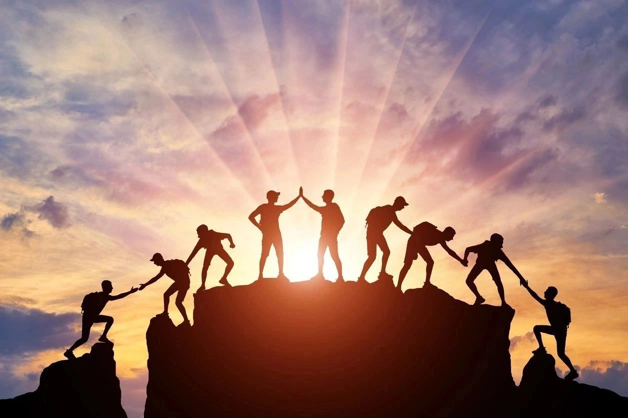 Group of people on peak mountain climbing helping teamwork