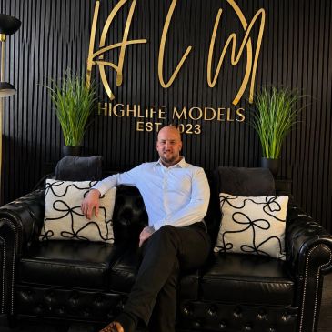 Man sitting on a black couch at Highlite Models.