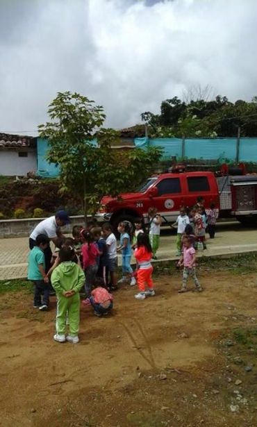 Children gathered near a fire truck outdoors.