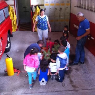 Children gathered inside a fire station with adults.