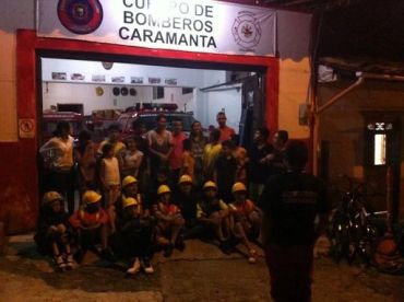 Group of children and adults at a fire station.