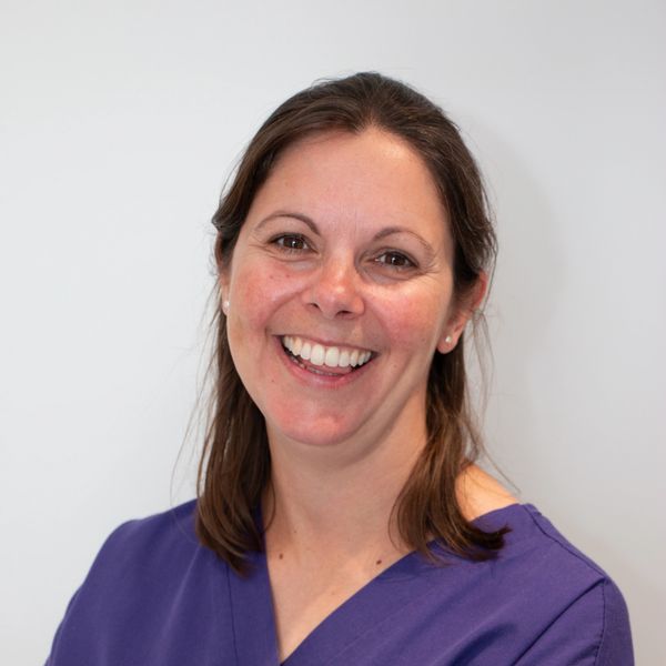 Lucy, a veterinary surgeon in scrub top smiling