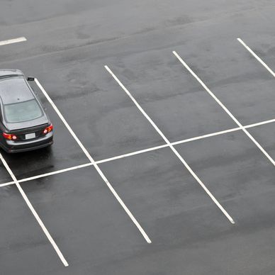 A car park with a gray car