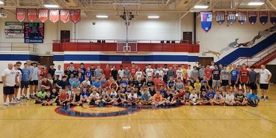 Large group of kids and adults posing in a gymnasium.