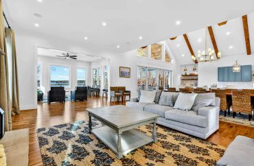 Custom home interior view showing front entry and vaulted ceiling timber framing.