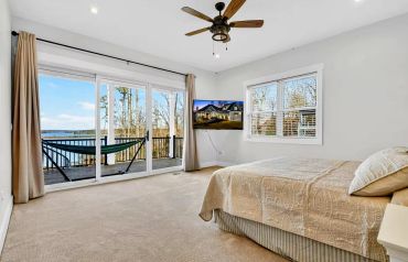Bright bedroom with water view and sliding glass doors.