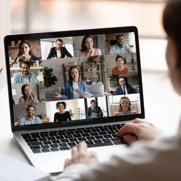 Person attending a virtual meeting on a laptop with multiple participants.