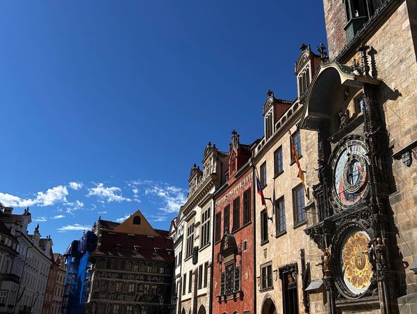 Historic Prague street with colorful buildings and the Astronomical Clock.