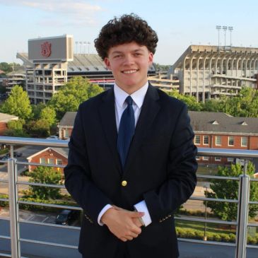 Young man in suit with stadium background.