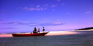 men riding a boat on the beach