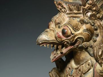 Close-up of an ornate mythical bird statue with intricate carvings.