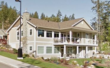 Spacious two-story house with beige exterior and large windows.