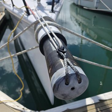Close-up of a sailboat's furled sail secured with ropes at the marina.