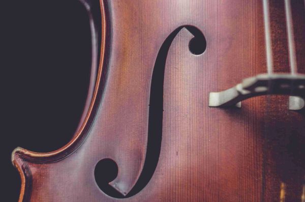 Close-up of a violin's f-hole and wooden body.