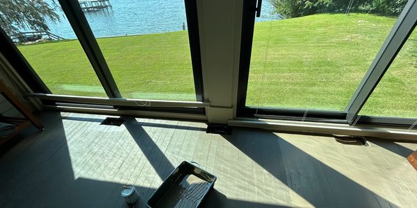 Photo of a porch floor in the middle of painting it with the Mobile Bay in the background. 