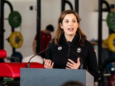 Lisa Weagle speaking at a podium at a Canadian Olympic Committee announcement in Calgary, Alberta