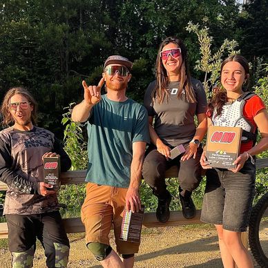 A group of four friends posing outdoors with bike gear.
