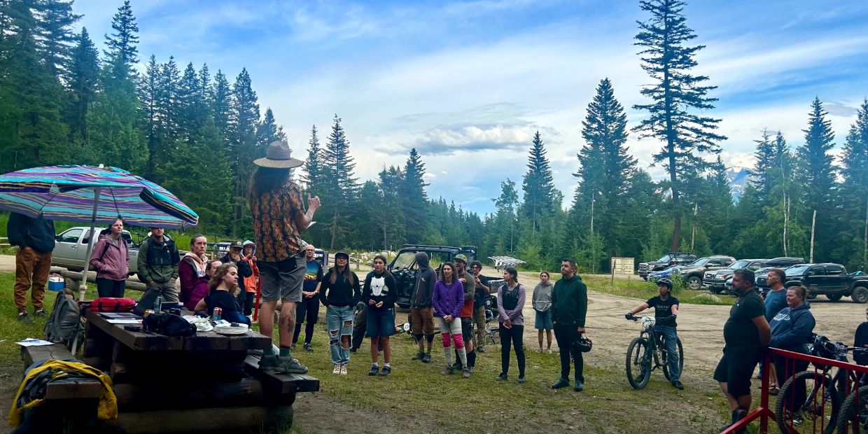 Group gathered outdoors for an event in a forested area.