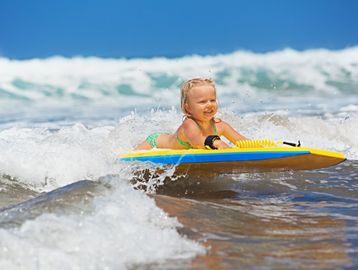 Little girl on a bodyboard in the sun, Beach Games Waikiki.