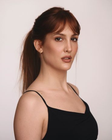 Mujer con vestido negro y cabello recogido.