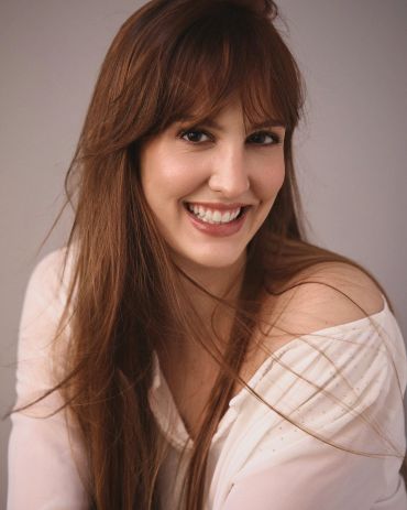 Mujer sonriente con cabello largo y suelto.
