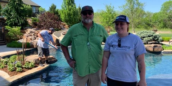 A woman with man stand Behind the swimming pool