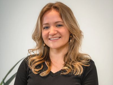 A photo of Katie Diehl headshot. Blond hair, smiling, looking into the camera.
