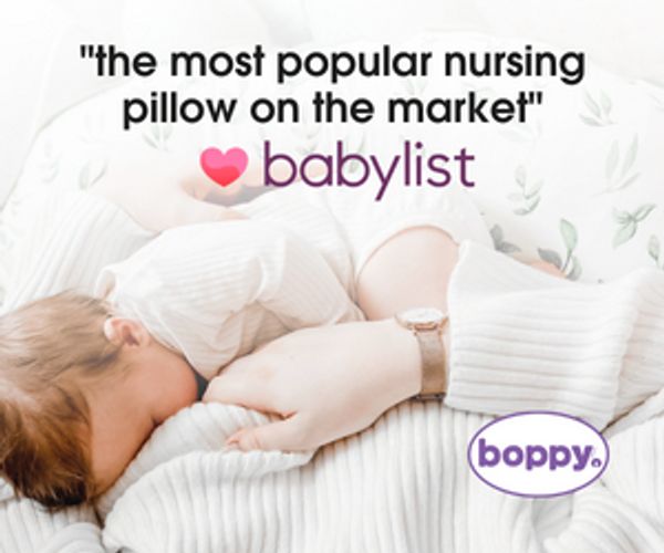 Mother breastfeeding baby using a popular Boppy nursing pillow.