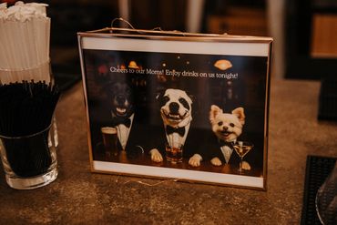 Framed photo of three dogs in tuxedos with drinks, celebrating moms.