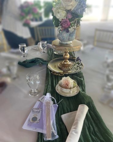Elegant wedding table setup with flowers, a tea cup, and bridal scratch card.