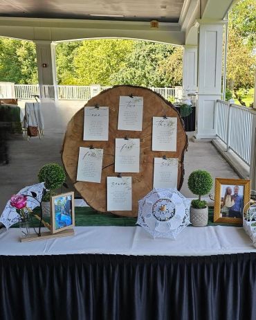 Wedding reception table with photos and decorative parasols.