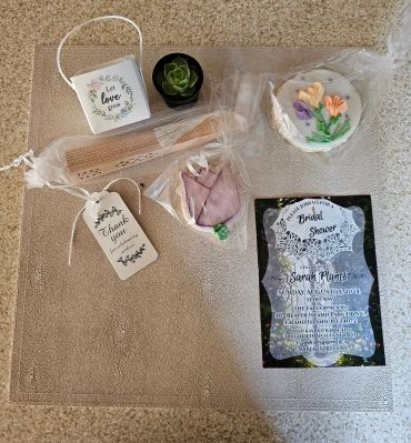 Bridal shower favors including cookies, a fan, a succulent, and a thank you tag.
