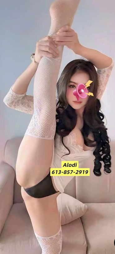 Woman in white lace outfit stretching leg high on couch.