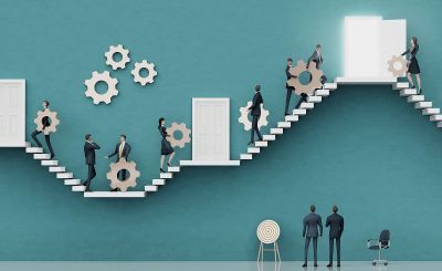 Businessmen moving gears on stairs towards an open door.
