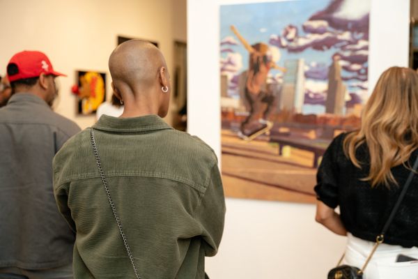 People viewing a painting in an art gallery.
