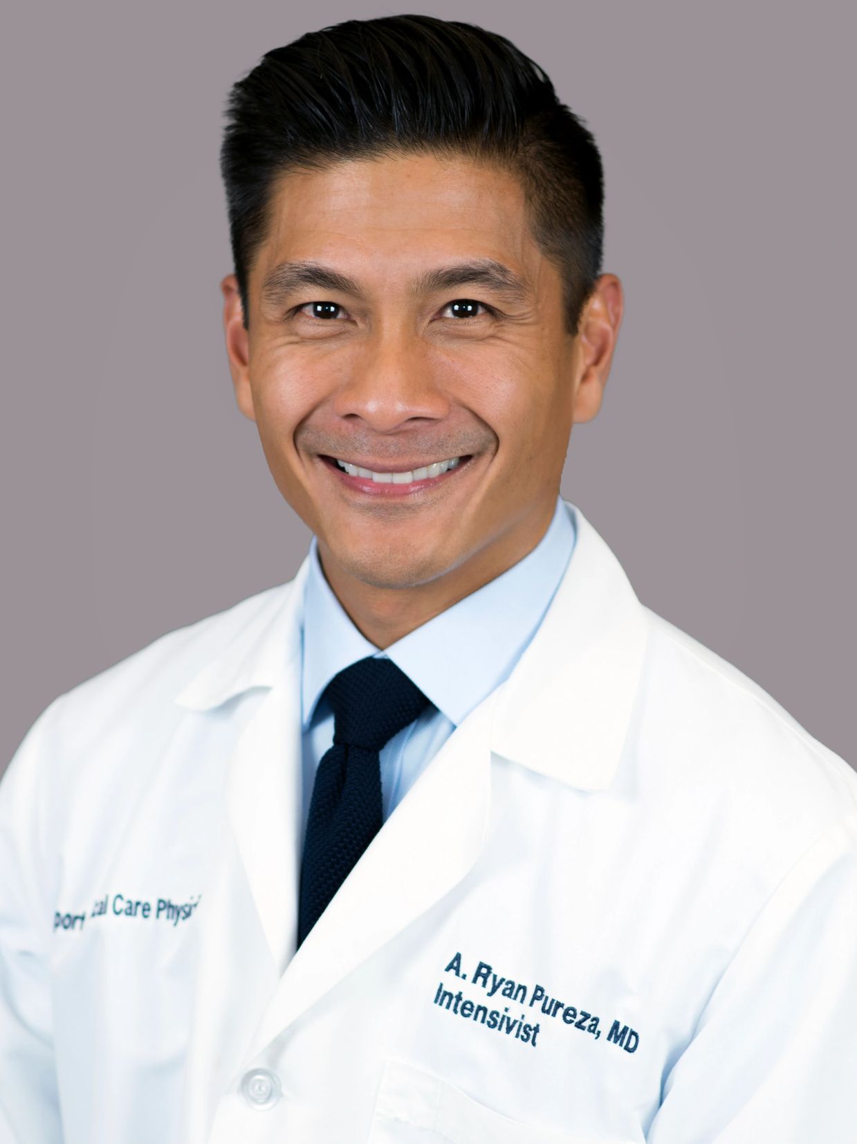 Portrait of a smiling male doctor in a white coat.