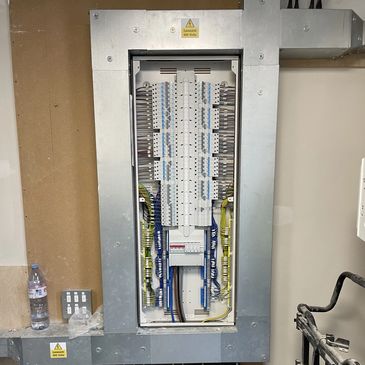 Electrical breaker panel with organized wiring inside a metal enclosure.