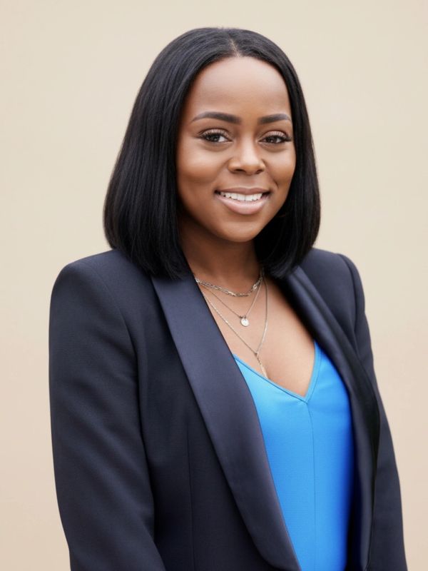 Smiling woman in black blazer and blue top.