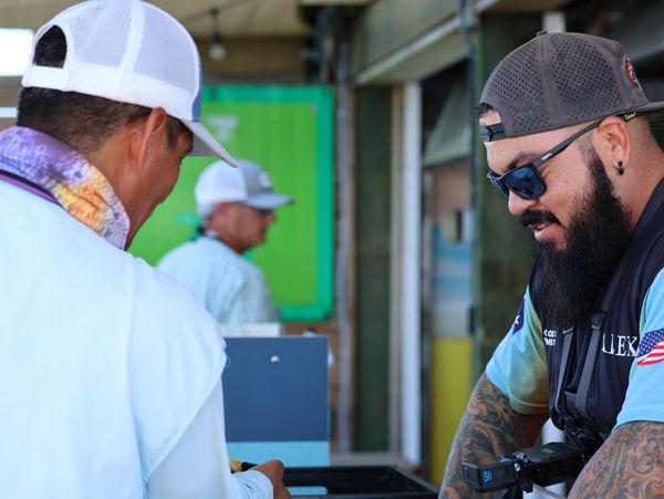 Professional weighmaster conducting fishing tournament weigh-in

