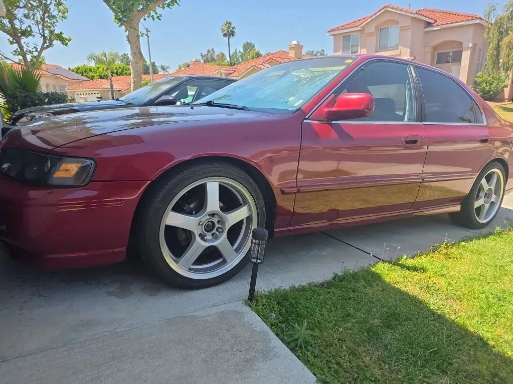Maroon sedan parked in a driveway on a sunny day.