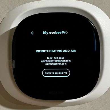 Smart thermostat displaying HVAC company contact information.