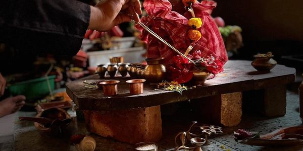 Traditional Indian ritual setup with copper vessels and floral decorations.