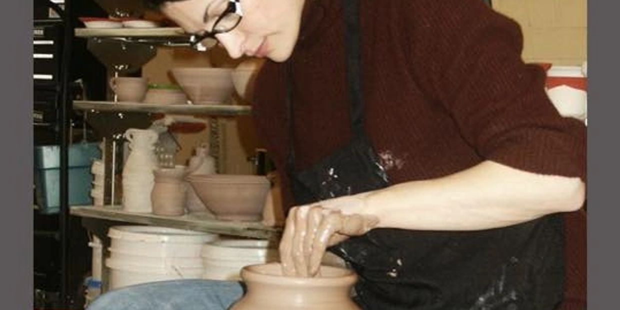 Potter and studio owner Nicole Dubrow demonstrates turning a vase during a field interview.